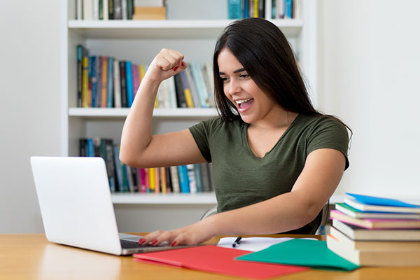 Teen girl on laptop cheering